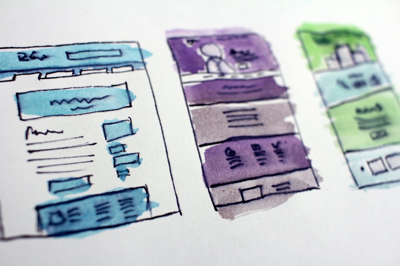 Hand-painted watercolor wireframes of three website layouts